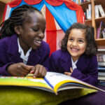 Smiling children reading together in the library