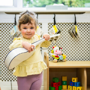 Nursery child playing with the guitar