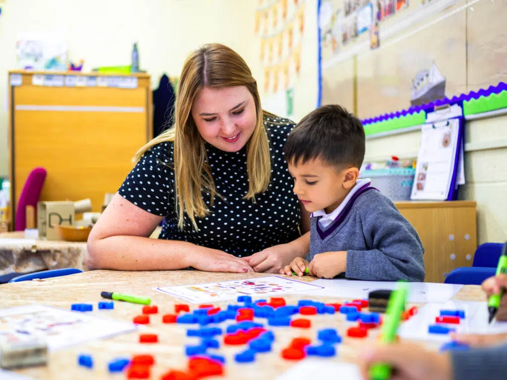 reception child working with teaching, laughing