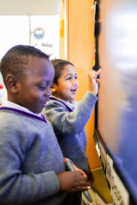 Pre-reception children having fun using interactive board 